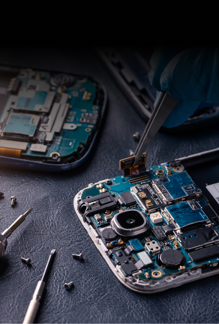 Close-up of smartphone motherboard being repaired with tools, showcasing intricate electronic components and circuitry.